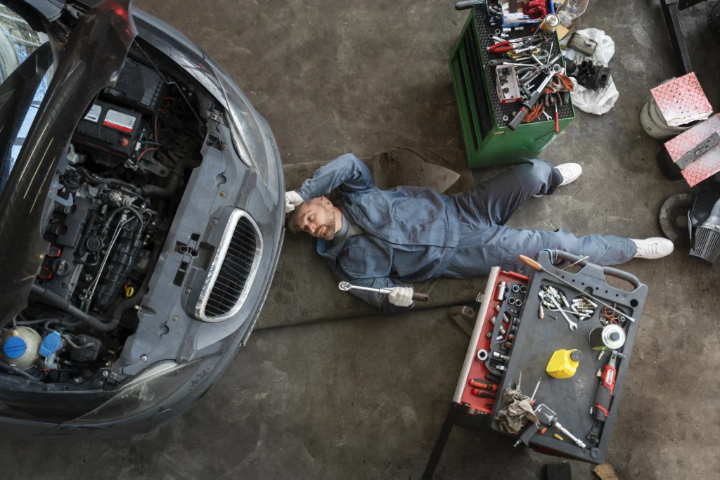 top-view-man-repairing-car by master mechanics